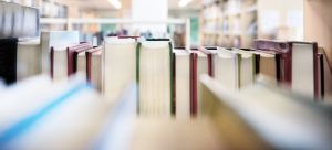 Bücher im Bücherregal einer Bibliothek mit Blick auf den jeweiligen Buchschnitt.